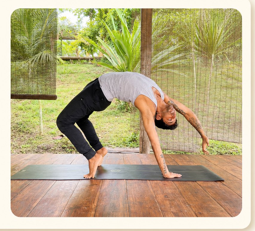 Varun in a standing backbend on a wooden deck surrounded by greenery